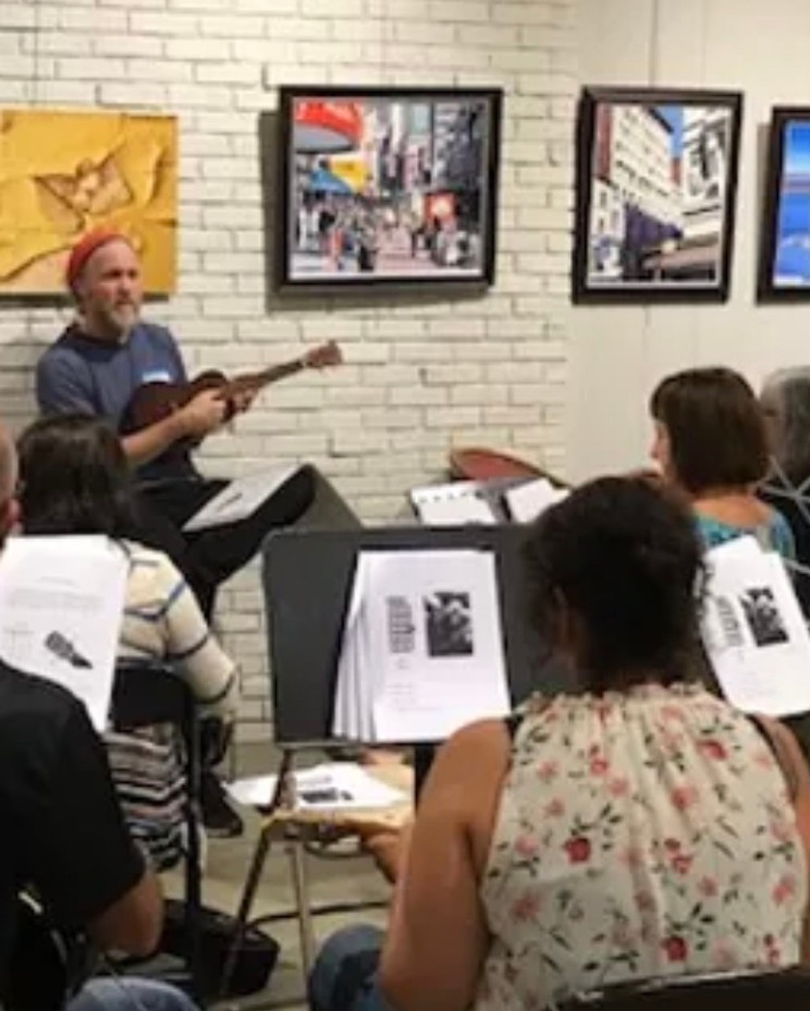 An instructor playing to a seated class in the gallery