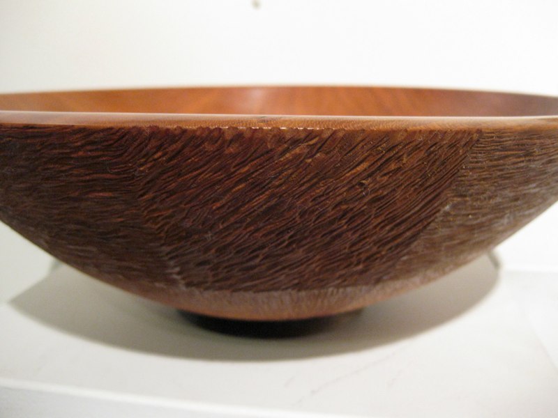 A turned wooden bowl with a carved exterior, shown at Gallery 9 in Norwood, Massachusetts